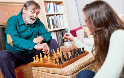 a shot of a senior playing chess with her daughter