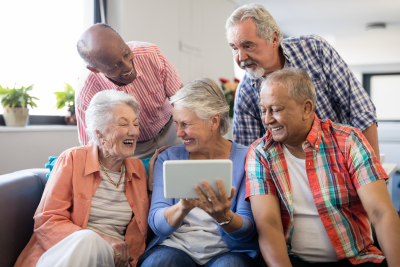 group of elderly watching movie on tablet gadget